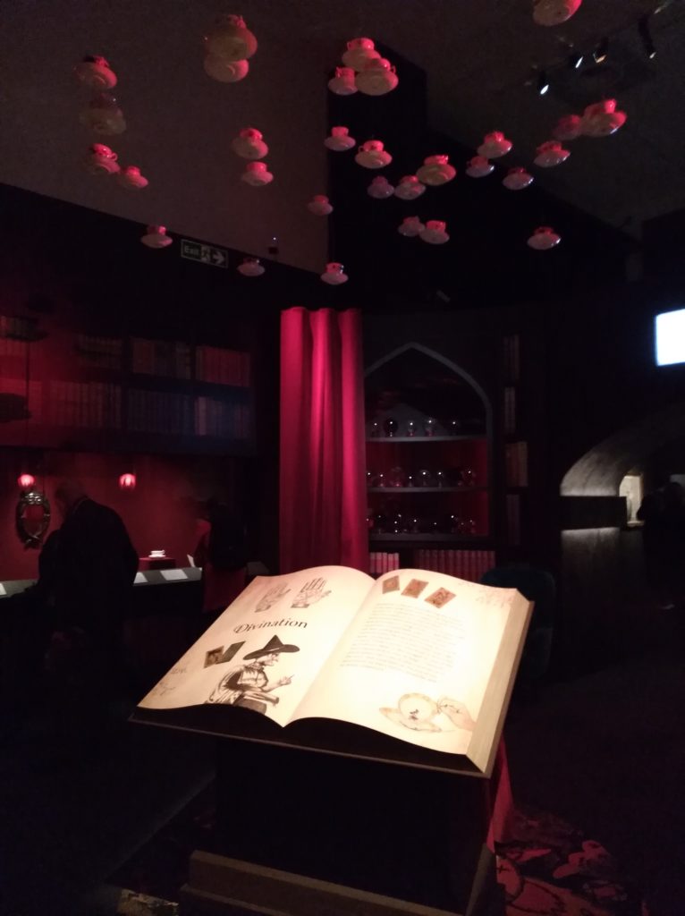 Section Divination de l'exposition Harry Potter de la British Library avec des tasses de thé qui pendent du plafond
