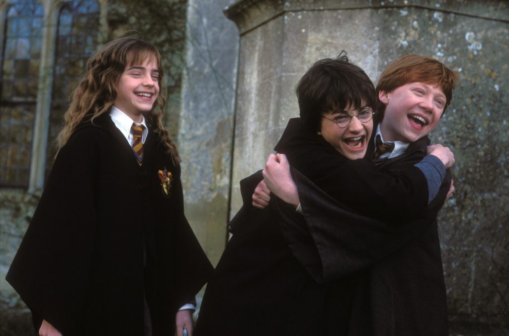 Harry et Ron se prennent dans les bras et sont hilares avec Hermione à l'arrière plan