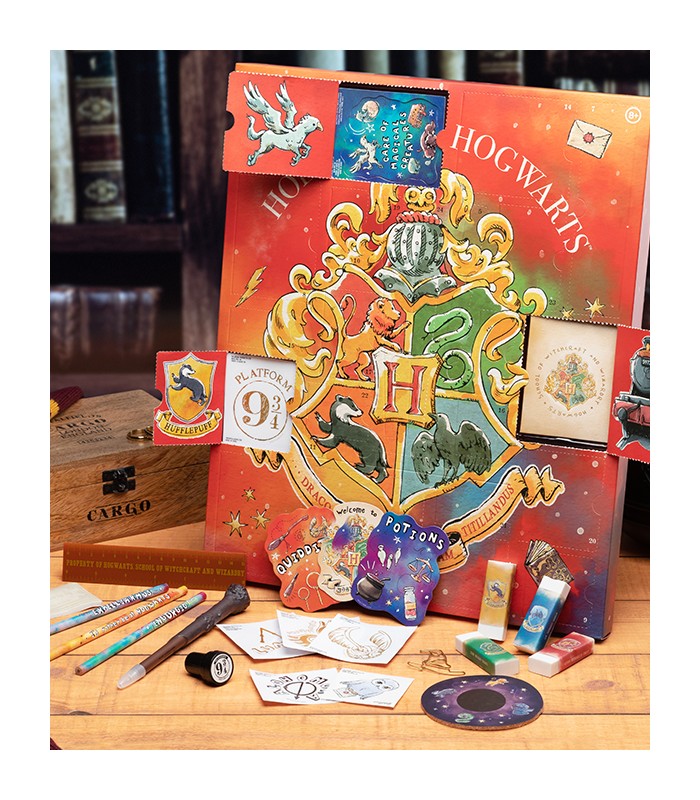 Aperçu de l'intérieur de trois cases du calendrier Pandalone 2021 avec détails des goodies : stylo baguette, crayons et gommes aux couleurs des quatres maisons, petites cartes thématiques, tampons